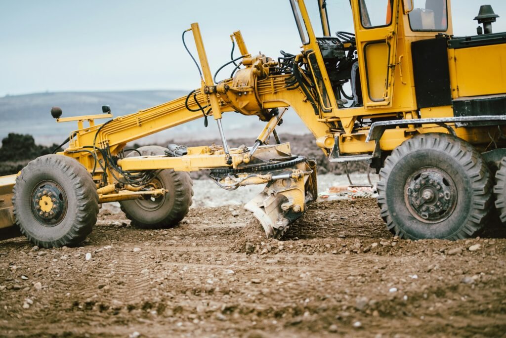 highway construction site development with motor grader moving earth, soil